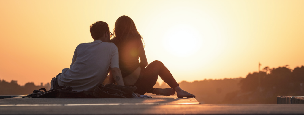 Couple face au soleil couchant 